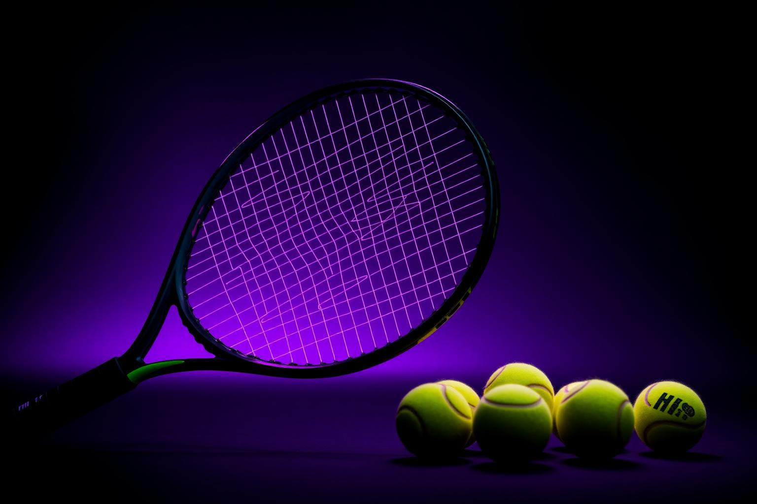 Black tennis racket with neon balls on purple background